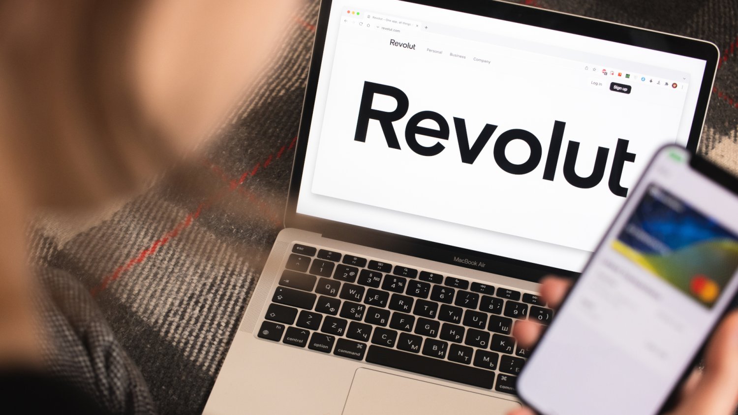 Kobieta przegląda aplikację i stronę Revoluta na komputerze