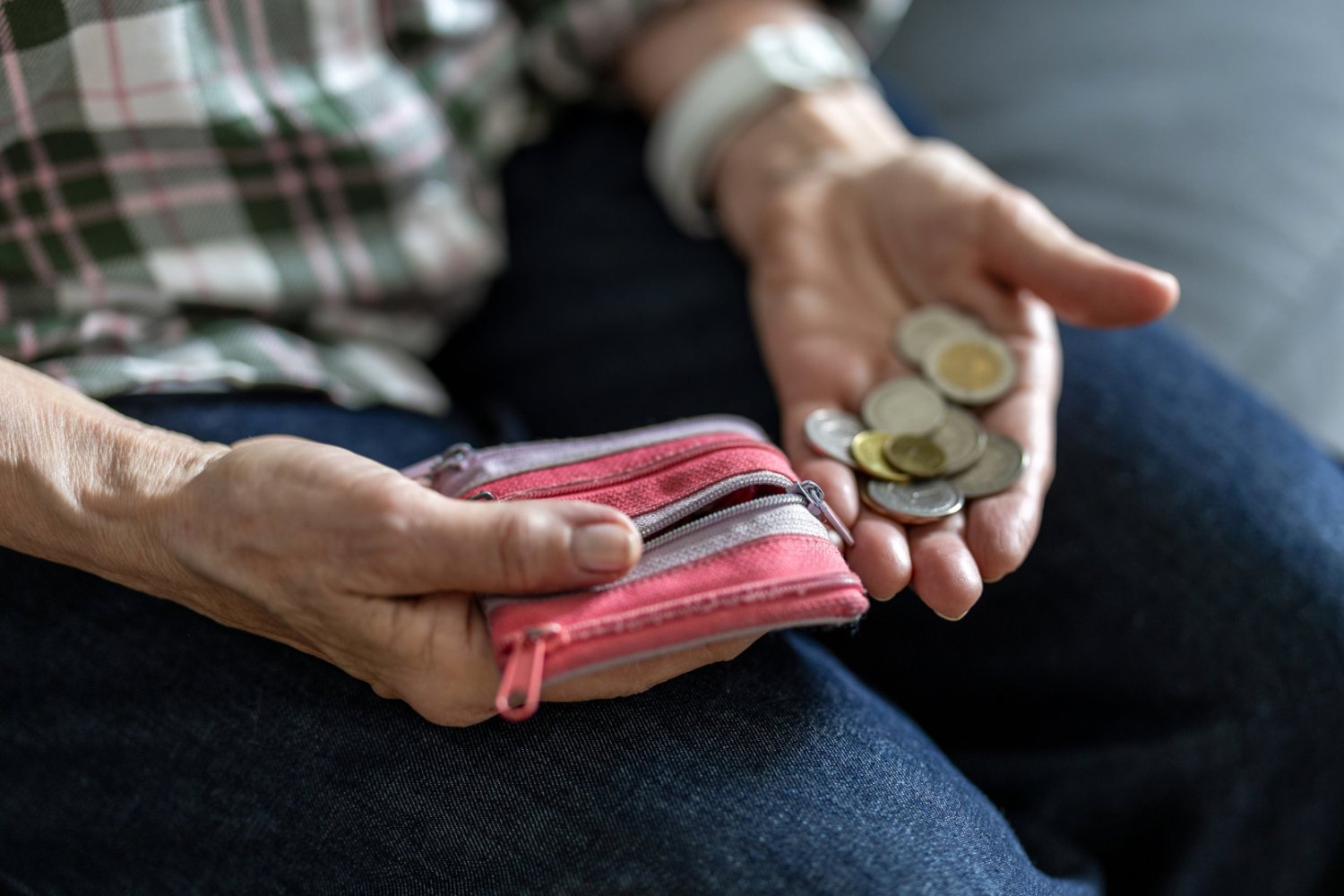 Starszy mężczyzna liczy pieniądze z portfela. Prognozowana waloryzacja emerytur 2027.