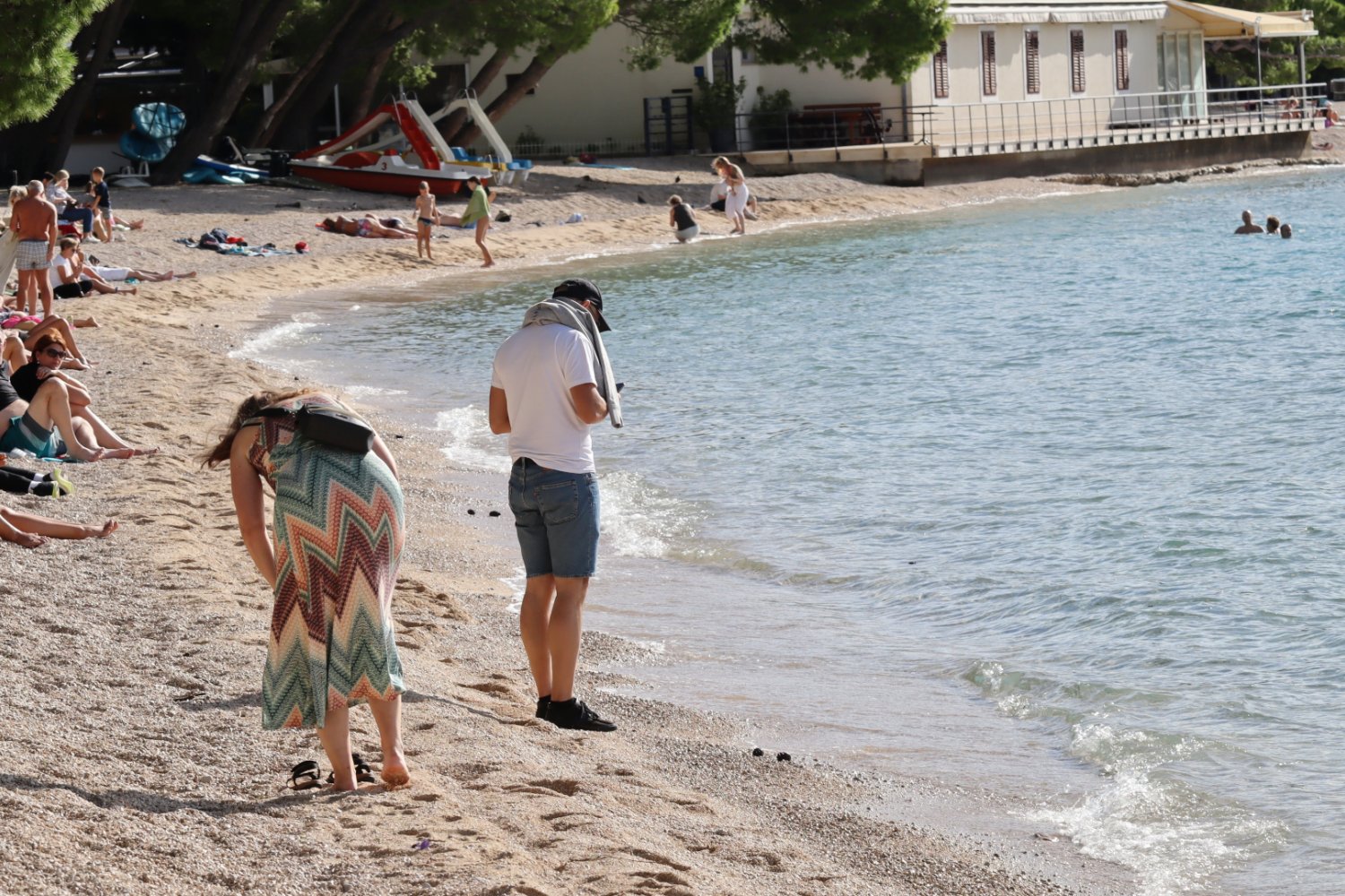Turyści na kamiennej plaży w Chorwacji