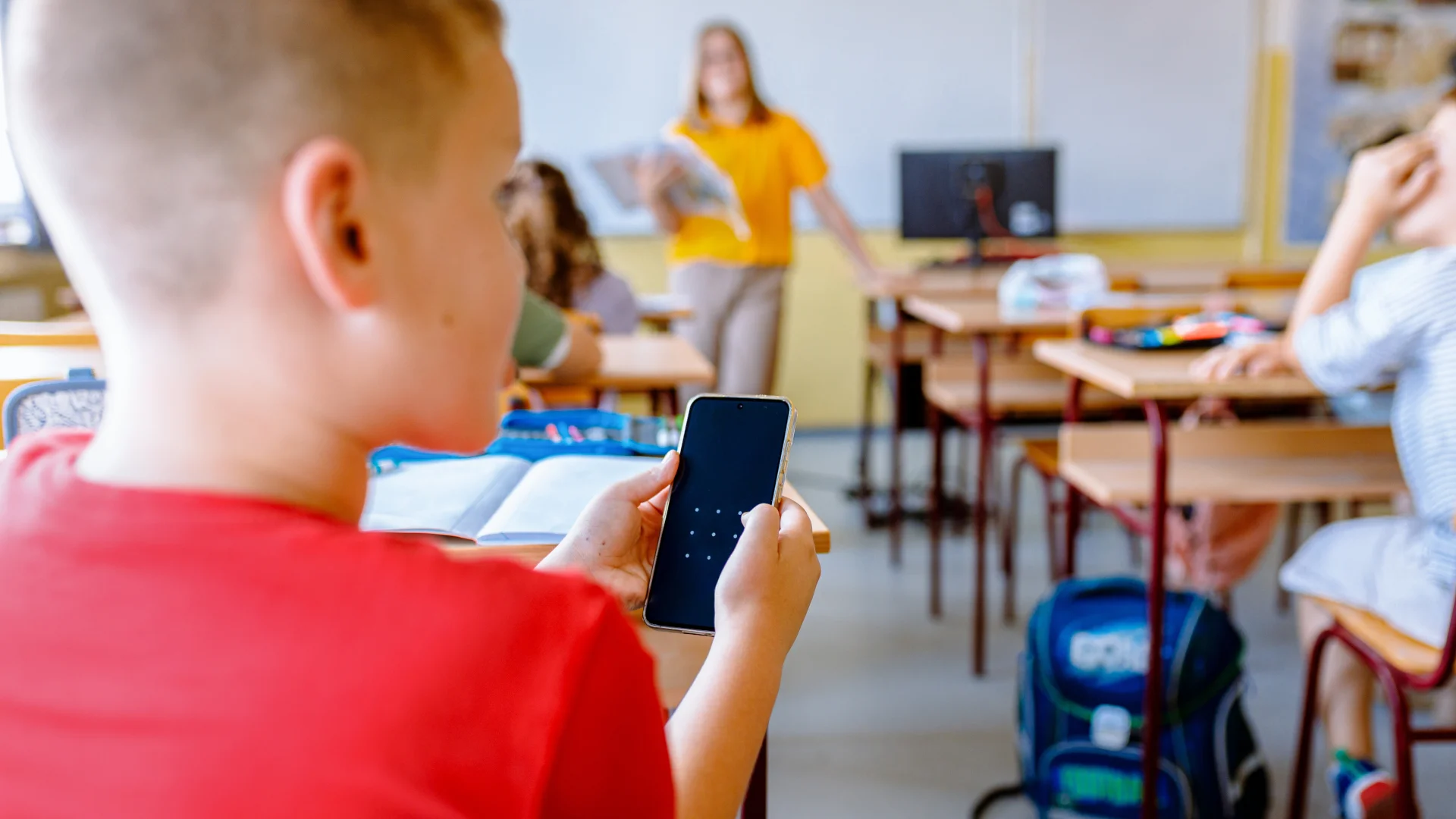 Uczeń na lekcji korzystający z telefonu