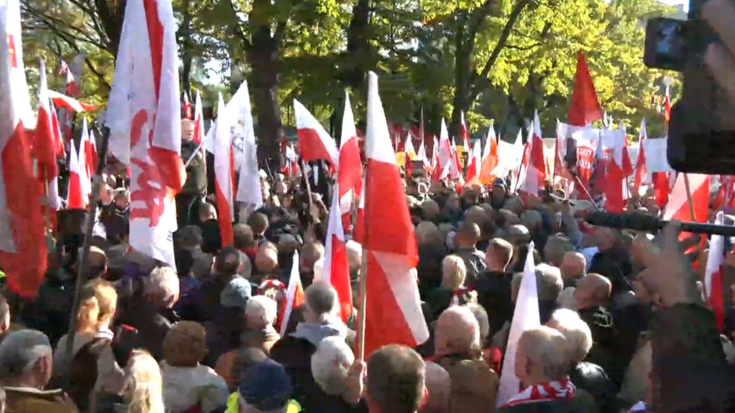 Uczestnicy manifestacji pod TK z biało-czerwonymi flagami