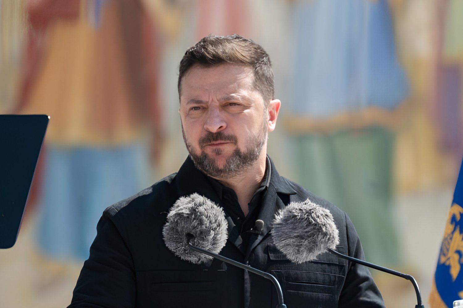 Wołodymyr Zełenski na tle barw narodowych Ukrainy w trakcie przemówienia.